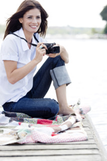Woman with camera sitting on dock. Date : 2008