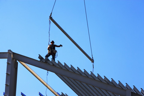 Construction worker standing on roof framing. Date : 2008