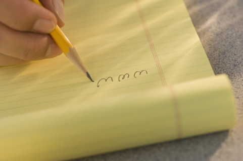 Man writing “www” on legal pad.