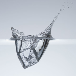 Ice cube splashing in water.