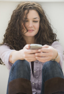 Woman text messaging on cell phone.