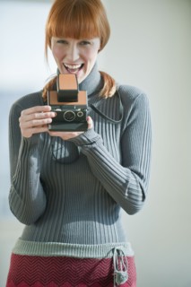 Woman holding vintage camera.