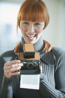 Woman holding vintage camera.