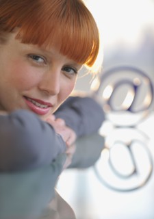 Woman looking at “at” symbol.