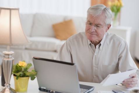 Senior man paying bills online.