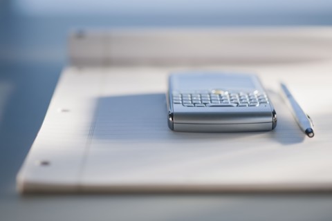 Close up of notepad and electronic organizer.