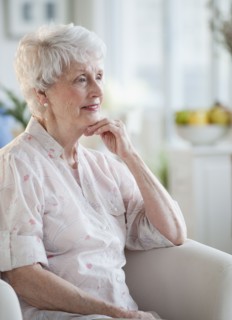 Senior woman sitting on sofa.