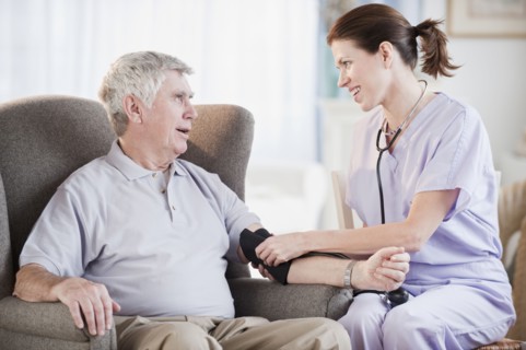 Nurse taking senior man’s blood pressure.