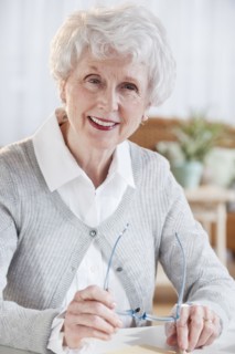Portrait of senior woman sitting at table.