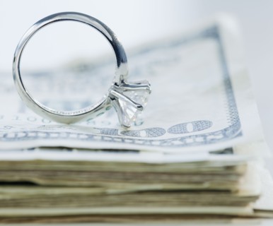 Wedding cake toppers on stack of cash. Photographe : Jamie Grill