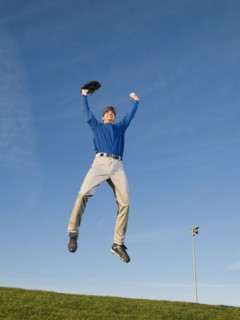 Baseball player jumping in air.