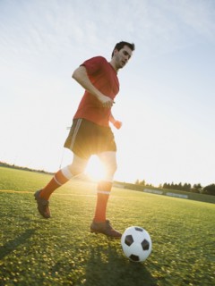 Soccer player dribbling ball.