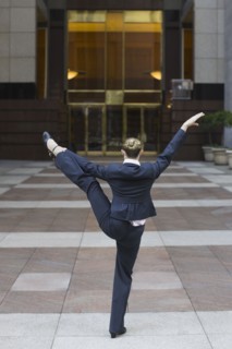 Businesswoman dancing in urban setting. Photographe : PT Images