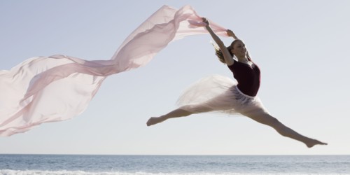 Dancer leaping on beach. Photographe : PT Images