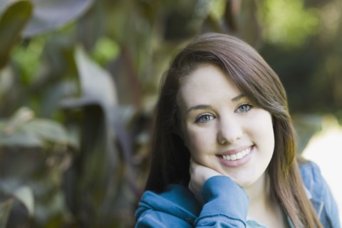 Portrait of teenage girl in park. Photographe : PT Images