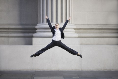 Businesswoman dancing in urban setting. Photographe : PT Images