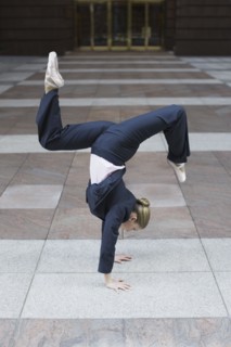 Businesswoman dancing in urban setting. Photographe : PT Images