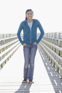 Teenage girl standing on dock. Photographe : PT Images