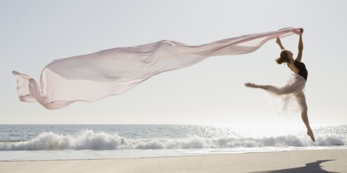 Dancer leaping on beach. Photographe : PT Images