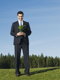 Businessman holding plant.