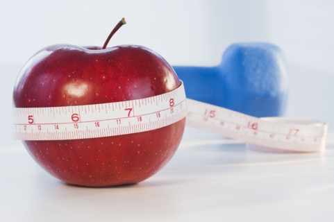 Apple wrapped in tape measure. Photographe : Daniel Grill