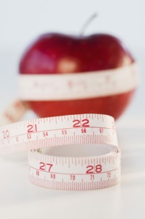 Apple wrapped in tape measure. Photographe : Daniel Grill