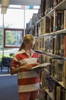 Girl reading book in library. Photographe : mark edward atkinson