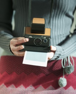 Woman holding vintage camera.