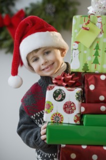 Boy posing with Christmas gifts.