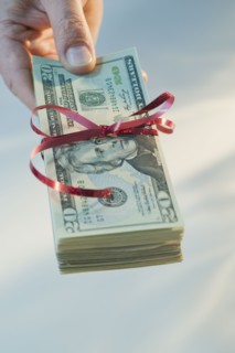 Man holding stack of money wrapped in ribbon.