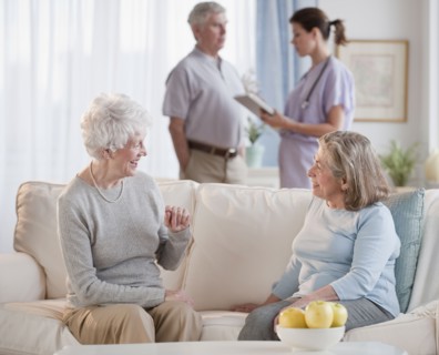 Senior woman talking on sofa.
