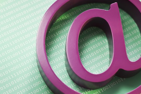 Close up of “at’ symbol and binary code.