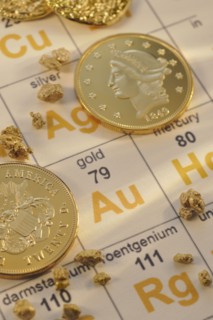 Periodic table of elements and gold coins.