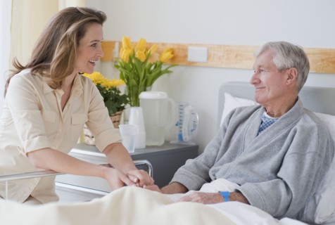 Daughter visiting senior father in hospital.