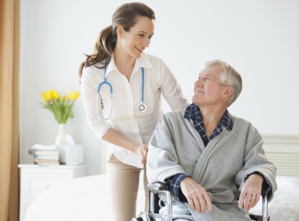 Nurse helping senior man in wheelchair.