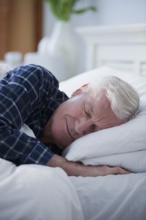 Senior man sleeping in bed.