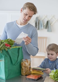 Father and son unpacking groceries.