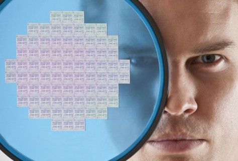 Close up of man looking through computer chip.