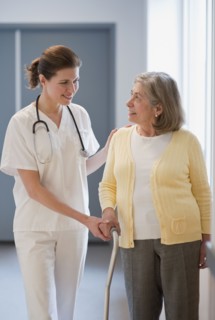 Nurse helping senior woman with cane.