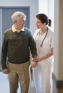 Nurse helping senior man with cane.