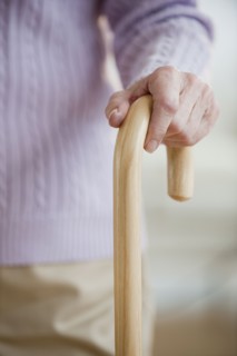 Close up of senior woman holding cane.