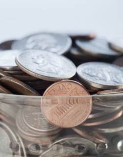 Coins in savings jar. Photographe : Jamie Grill