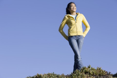 Teenage girl standing on hill. Photographe : PT Images