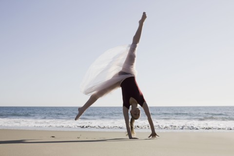 Dancer leaping on beach. Photographe : PT Images