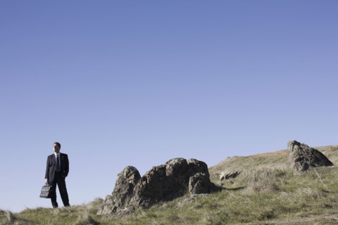 Businessman standing on remote hill. Photographe : PT Images