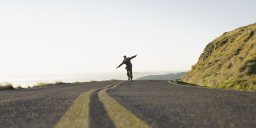 Businessman running on remote road. Photographe : PT Images