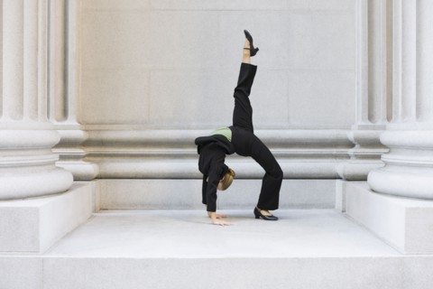 Businesswoman dancing in urban setting. Photographe : PT Images