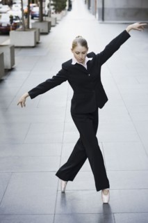 Businesswoman dancing in urban setting. Photographe : PT Images
