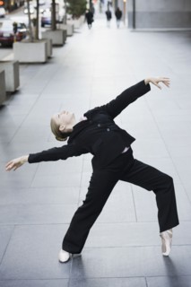 Businesswoman dancing in urban setting. Photographe : PT Images