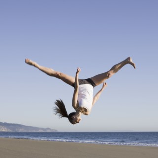 Woman jumping on beach. Photographe : PT Images